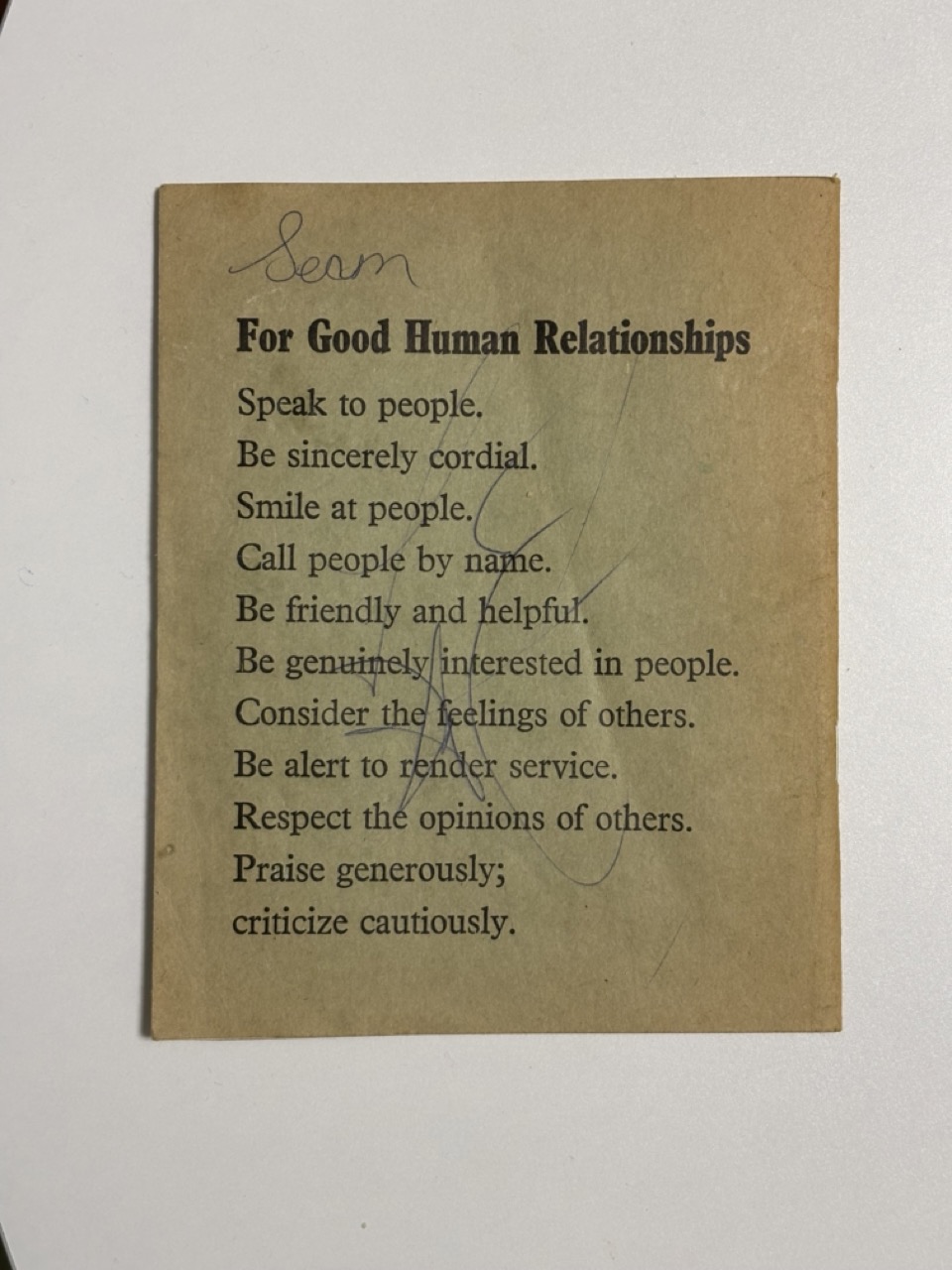 Photograph of an exercise book back cover, it reads: Sean(?) For Good Human Relationships. Speak to people. Be sincerely cordial. Smile at people. Call people by name. Be friendly and helpful. Be genuinely interested in people. Consider the feelings of others. Be alert to render service. Respect the opinions of others. Praise generously; criticize cautiously.